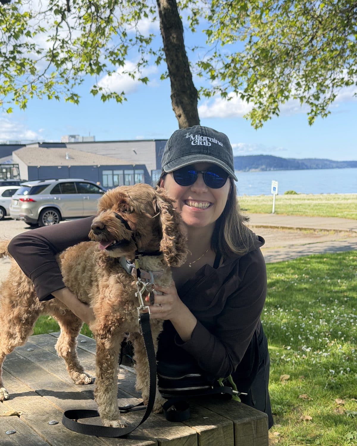 Deena, support group facilitator at The Migraine Network, smiling with one of her dogs